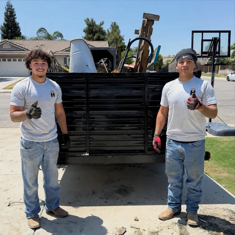 The Haulo Junk Removal crew in front of the company dump trailer