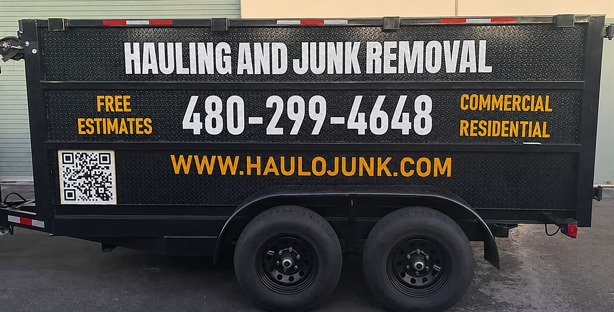 The Haulo dump trailer lettered with Hauling and Junk Removal, free estimates, commercial and residential, 480-299-4648 and haulojunk.com