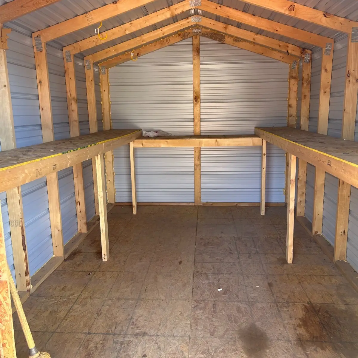 The same Apache Junction shed empty to its wood floor with the built-in wooden shelves clear