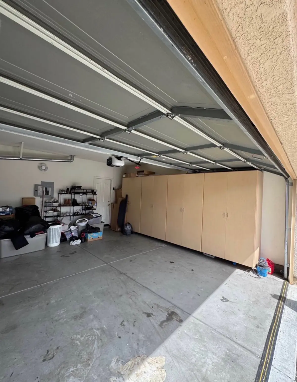 The same Chandler garage with the floor clear to the cabinets; the shoe rack and bins along the wall remain