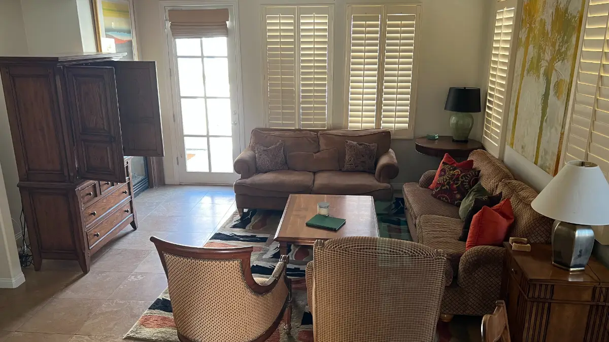 A Fountain Hills living room with plantation shutters, two sofas, an armoire and a coffee table