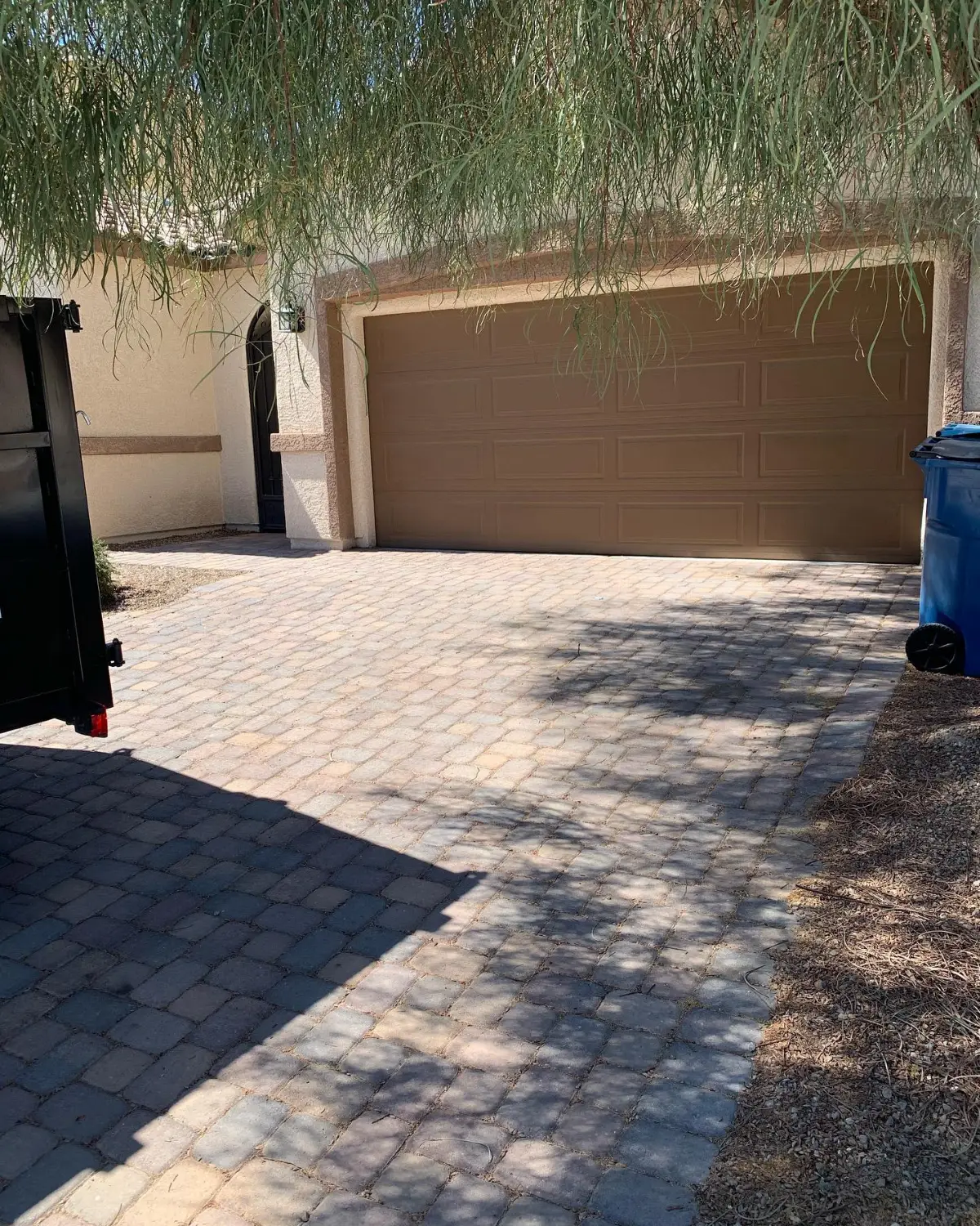 The same Gilbert paver driveway clear, with the edge of the Haulo trailer at the left and bins at the right