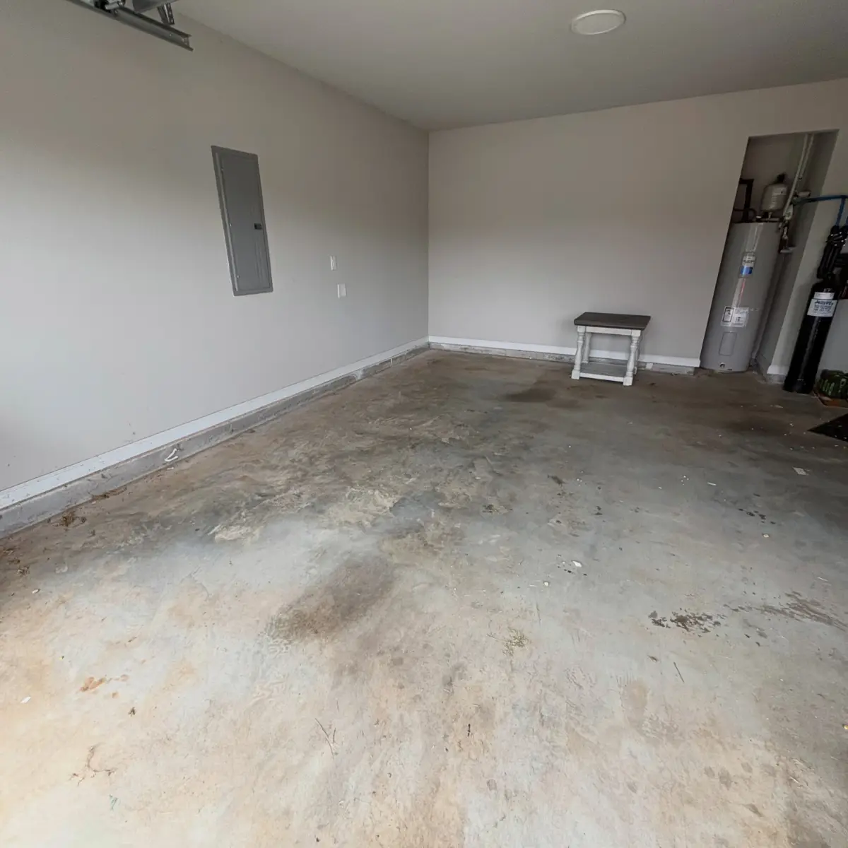 The same Gilbert garage empty to the walls except a small side table by the water heater