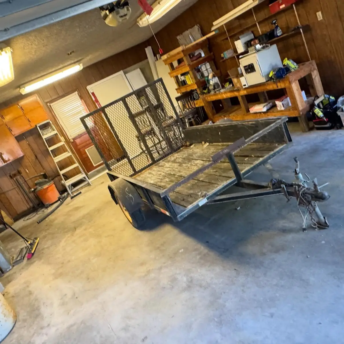 The same Glendale garage with the debris gone and the floor clear; the trailer, workbench and ladder remain