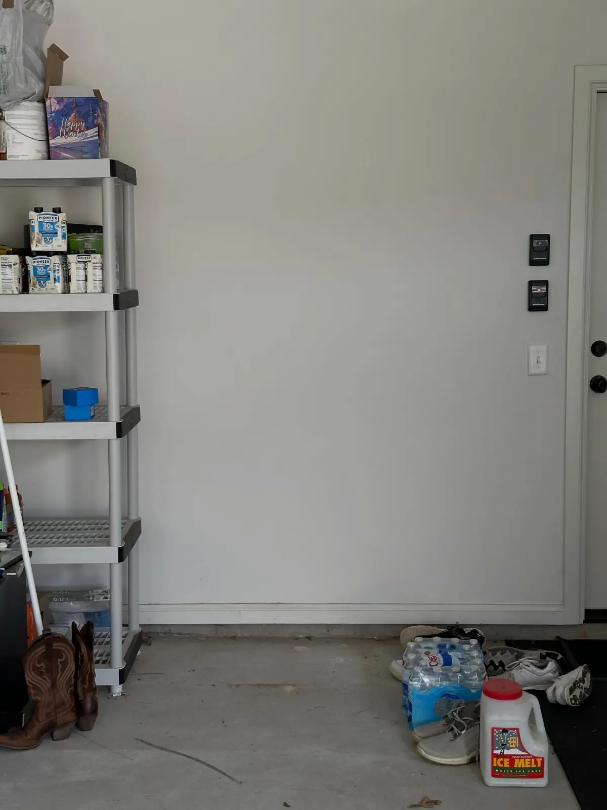 The same Mesa garage wall with the refrigerator removed; the shelving and stored items remain