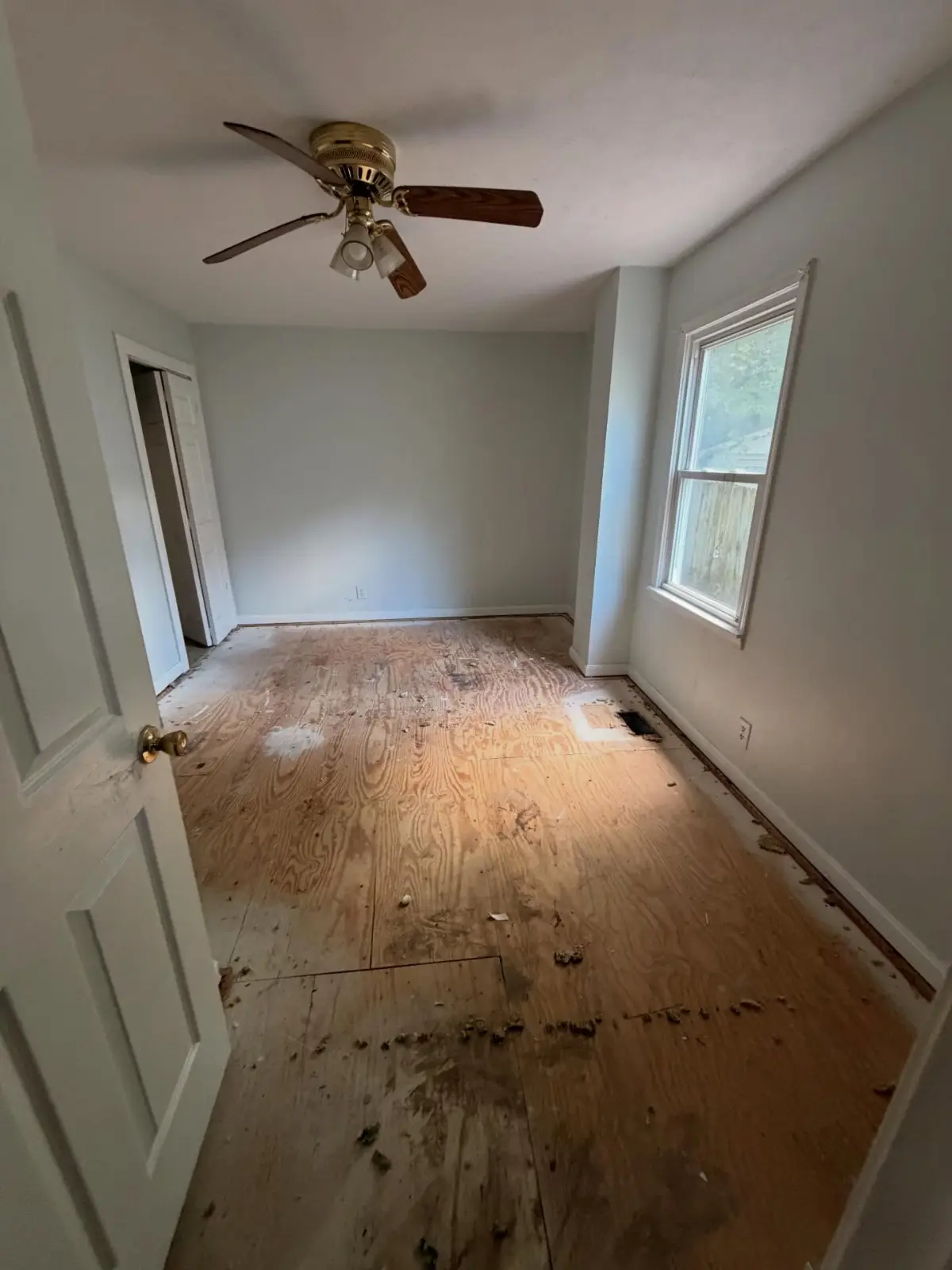 The same Mesa bedroom after Haulo removed the contents and pulled the carpet, leaving the subfloor exposed