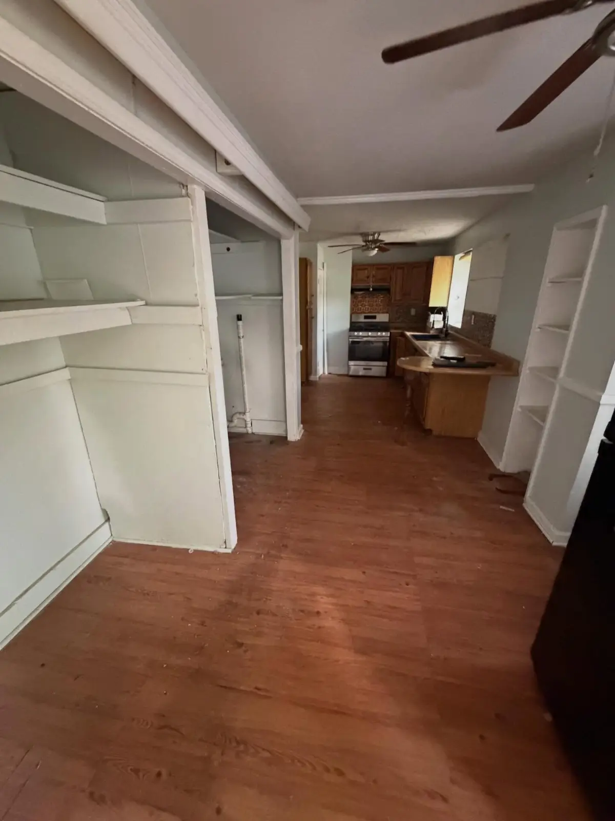 The same Mesa dining room cleared, with the furniture, rug, and floor contents removed and the built-in shelving emptied