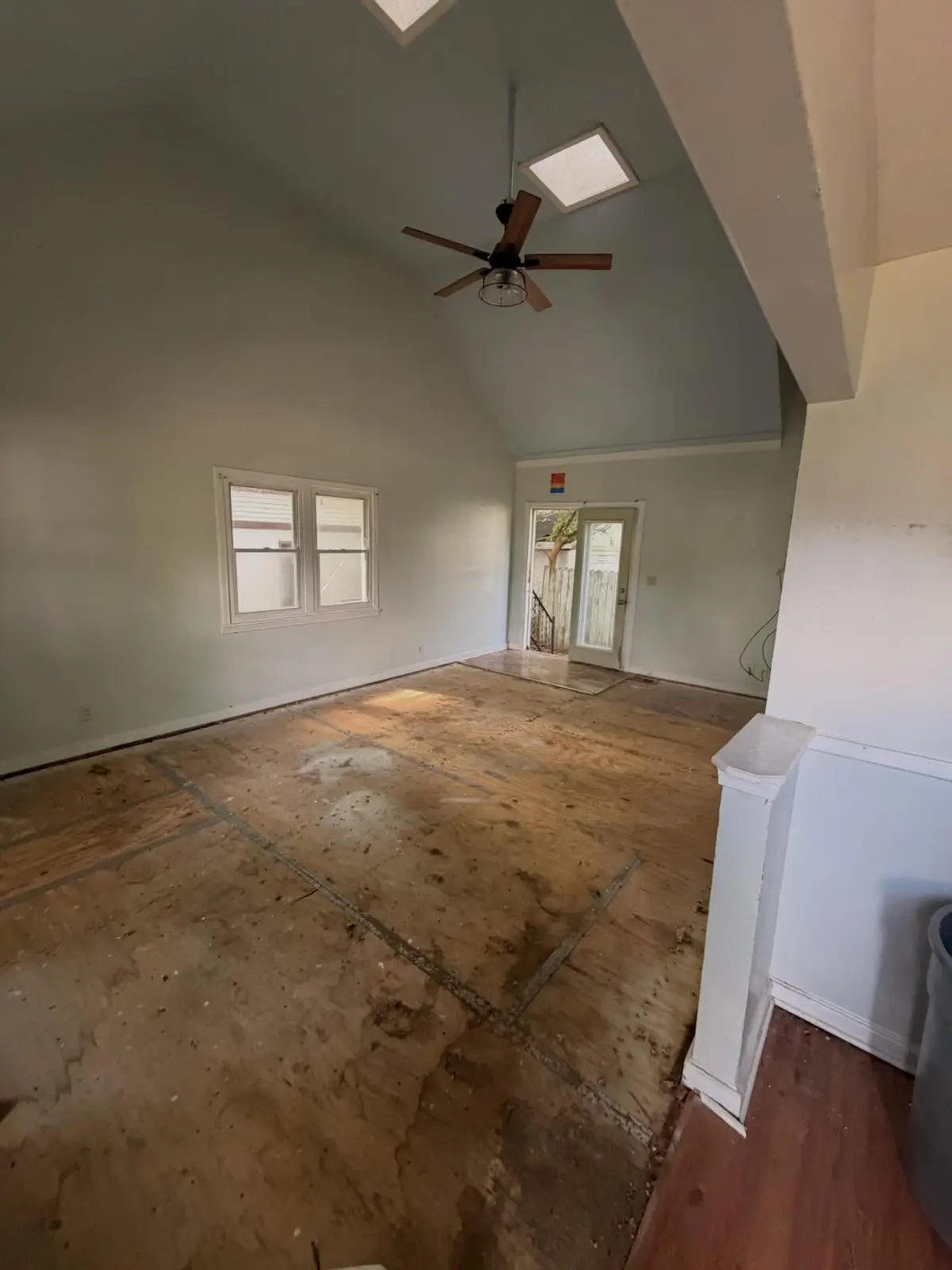The same Mesa living room after Haulo removed the contents and pulled the carpet, leaving the subfloor exposed