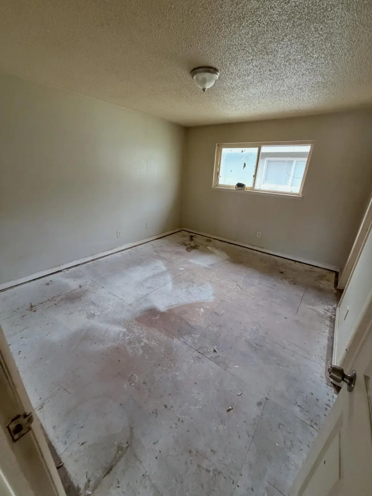 The same Mesa bedroom empty to the bare subfloor with the window clear
