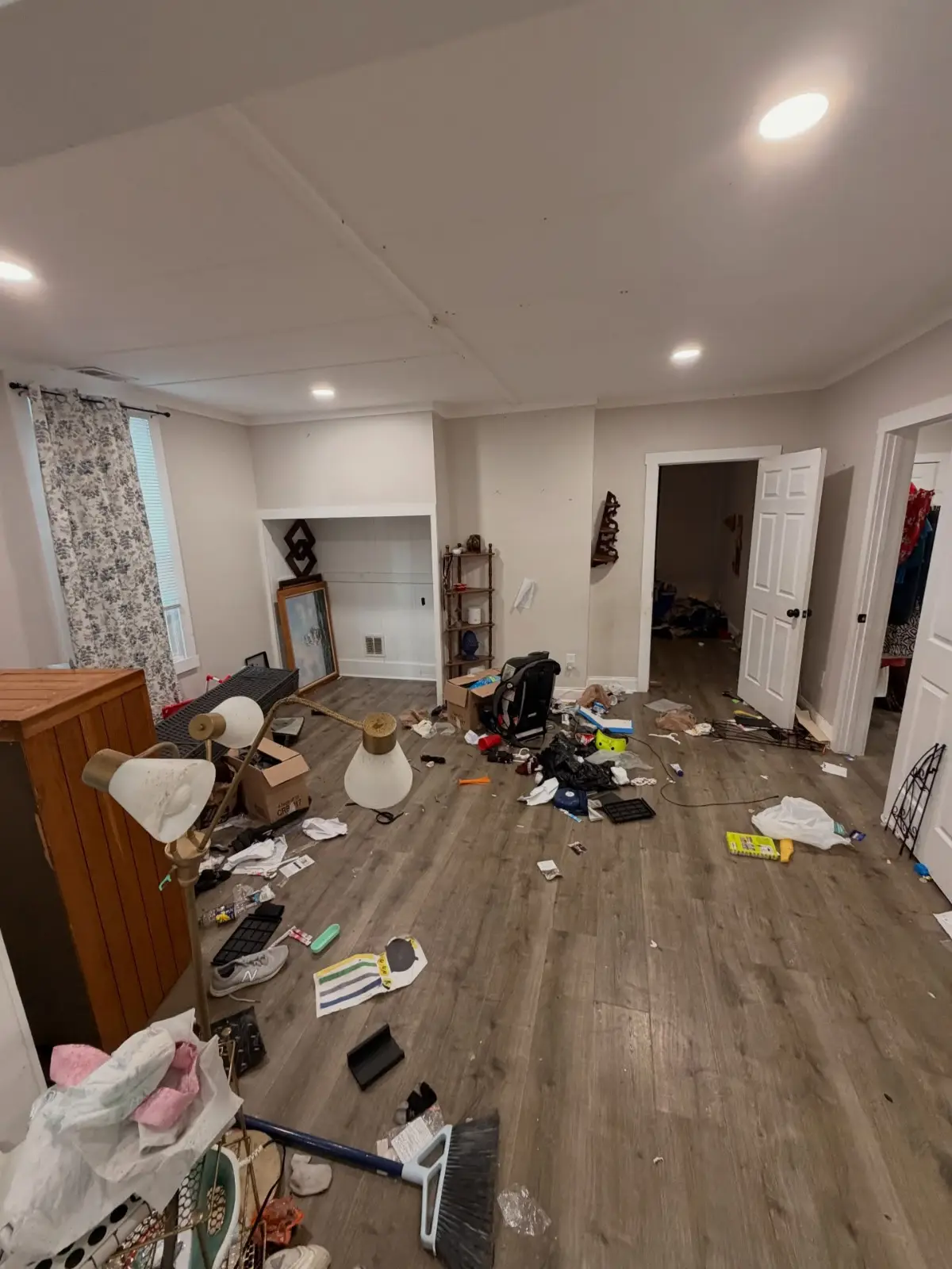 Living room and nook in a Mesa home before a cleanout, with a dresser, floor lamps, boxes, and scattered household items