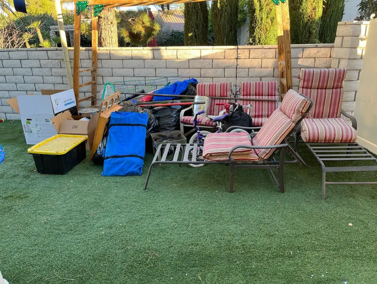 Patio loungers, a pop-up canopy, a bike and bagged items crowded on the turf of a Paradise Valley backyard