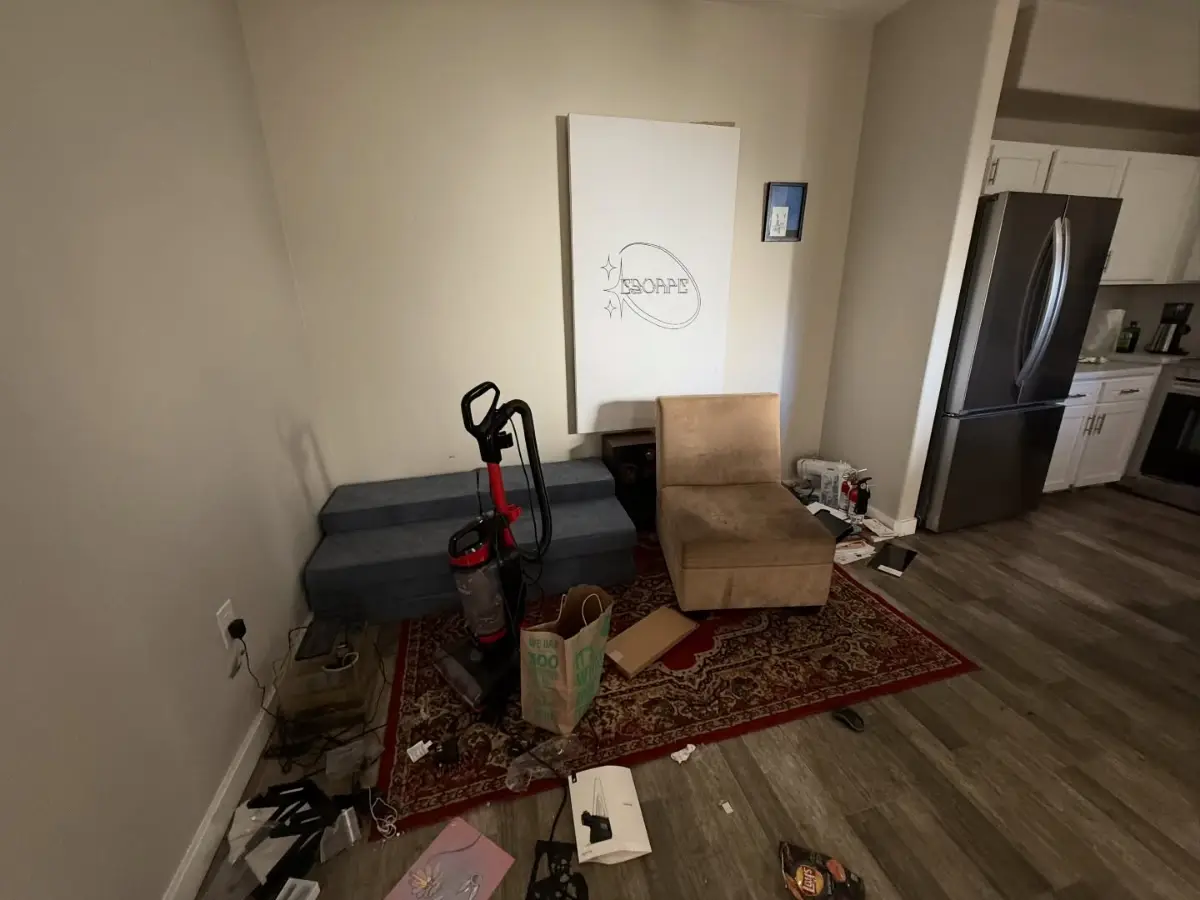 A Phoenix apartment kitchen entry with a chair, a vacuum, a rug and loose items in front of the refrigerator