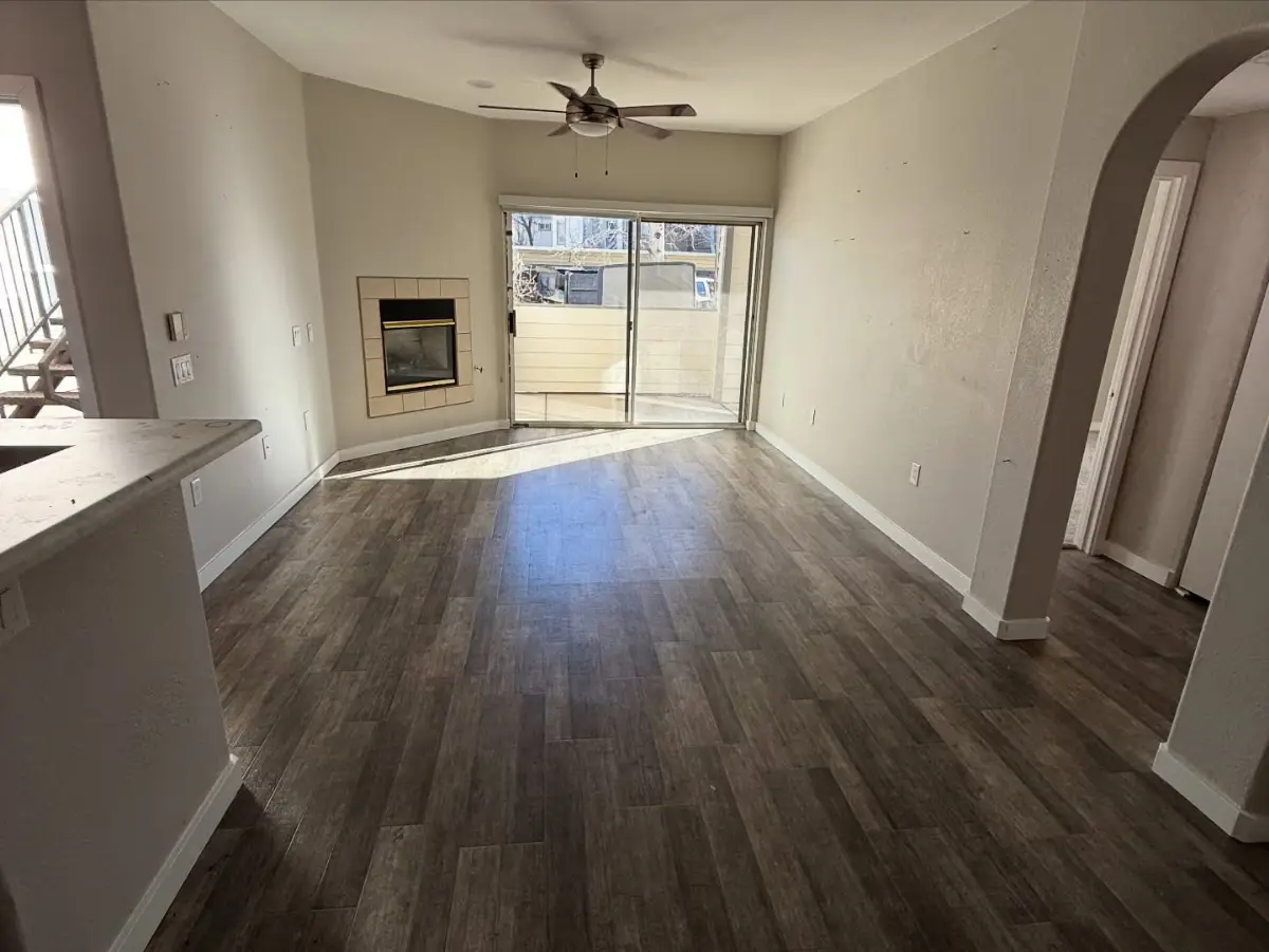 The same Phoenix apartment living room empty with the fireplace and patio door clear