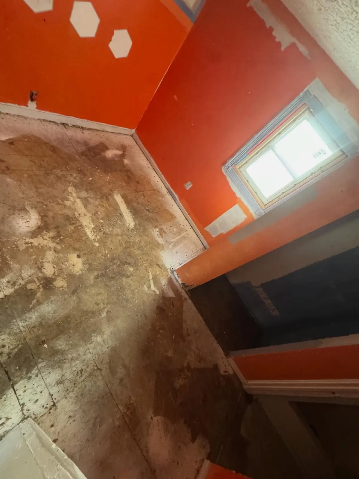 The same Phoenix bedroom with the carpet and pad pulled and the subfloor exposed