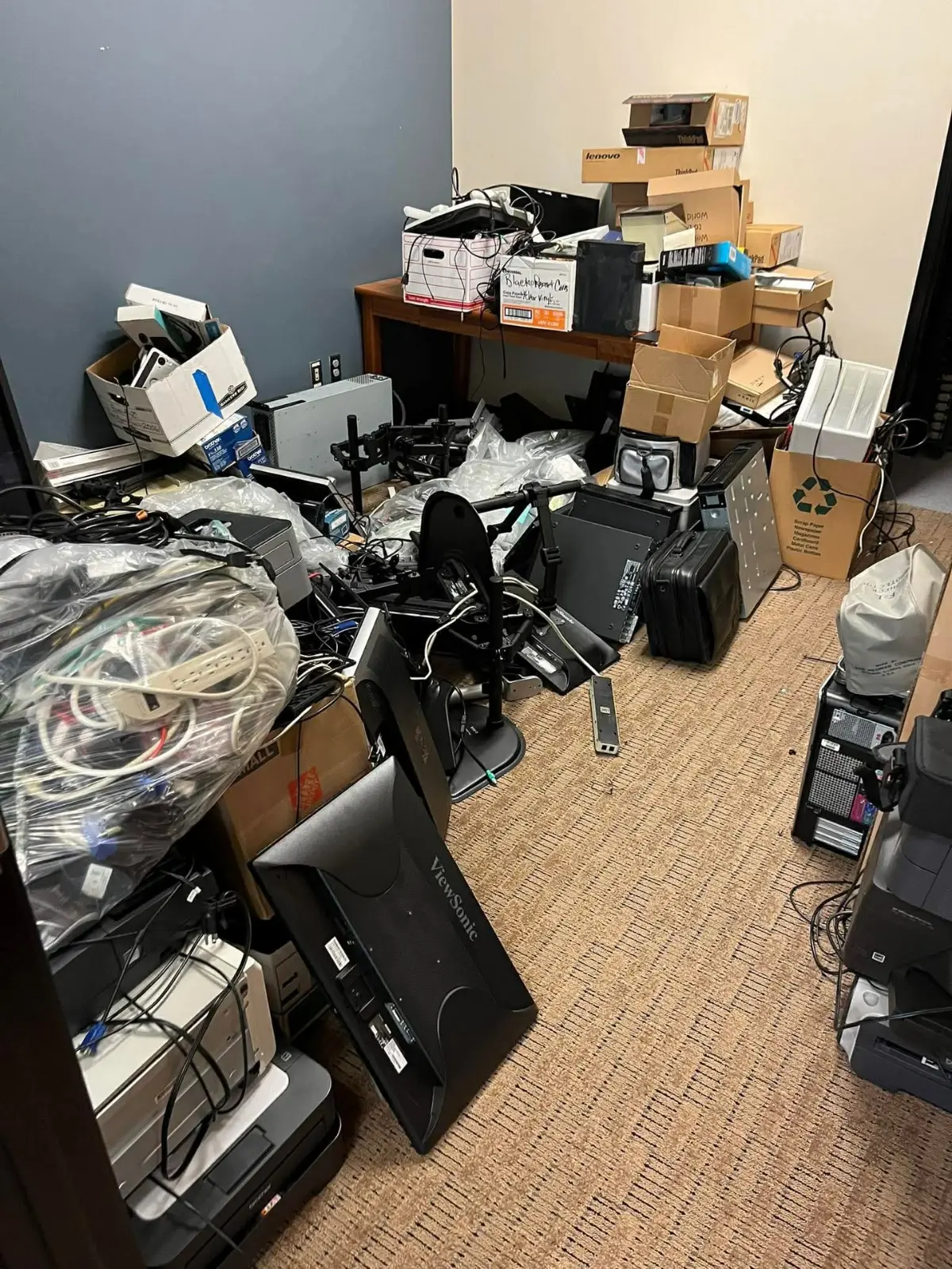 A Phoenix office room filled with monitors, desktop towers, printers, monitor arms and stacked equipment boxes