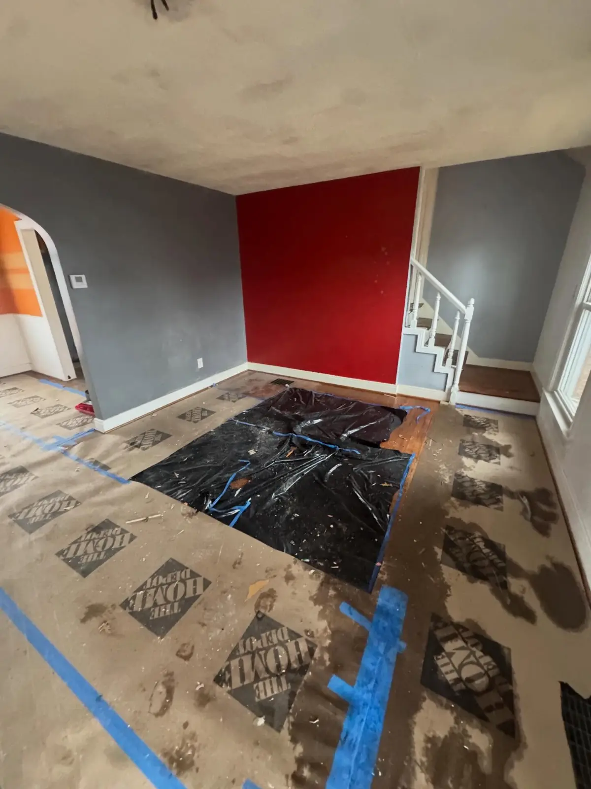 The same Phoenix living room with the debris pile gone and the floor protection left in place
