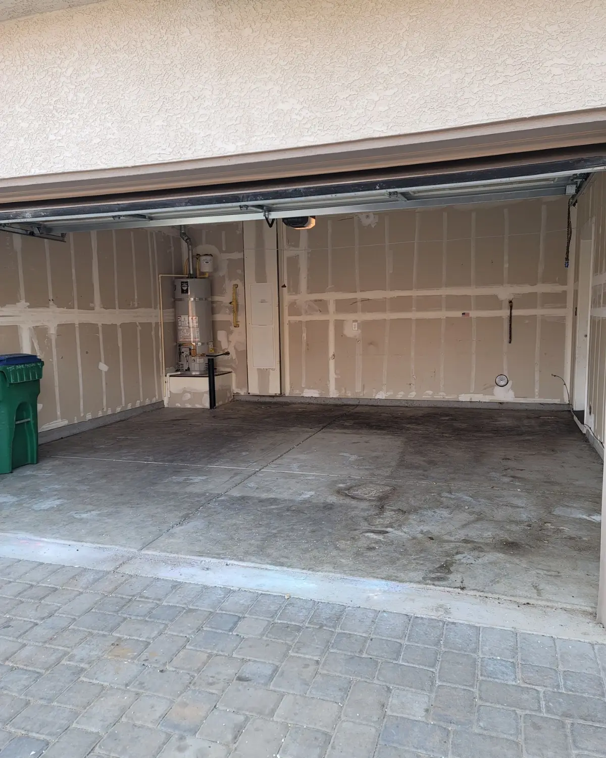 The same Phoenix garage cleared to the bare slab with the water heater visible