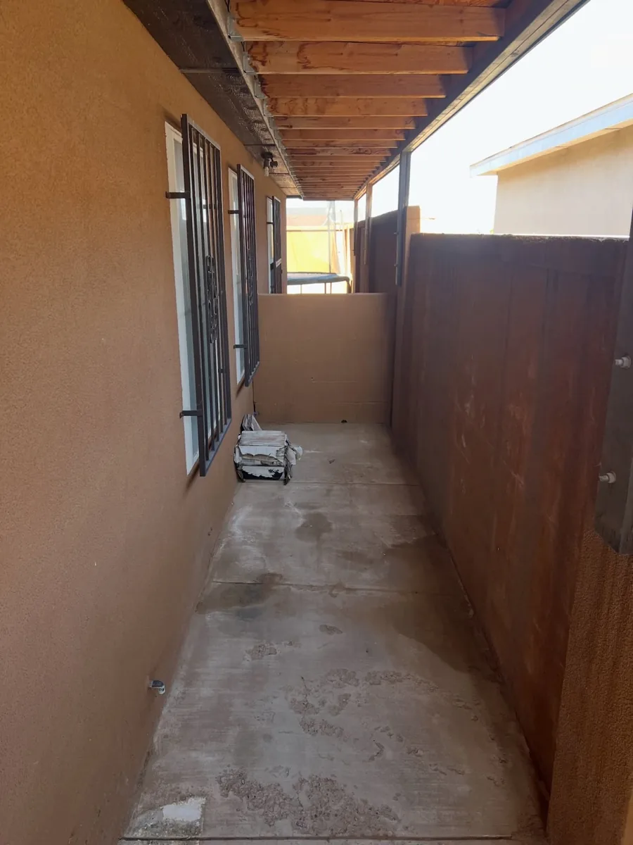 Open side-yard walkway after junk removal at a Phoenix property