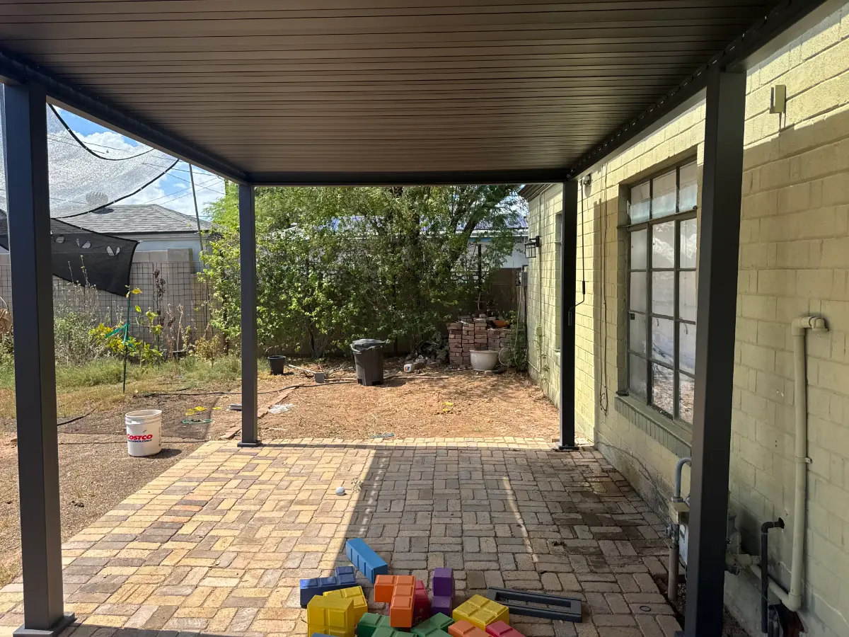 The same Phoenix backyard clear after the playset was dismantled and hauled; bricks and a bin remain along the wall