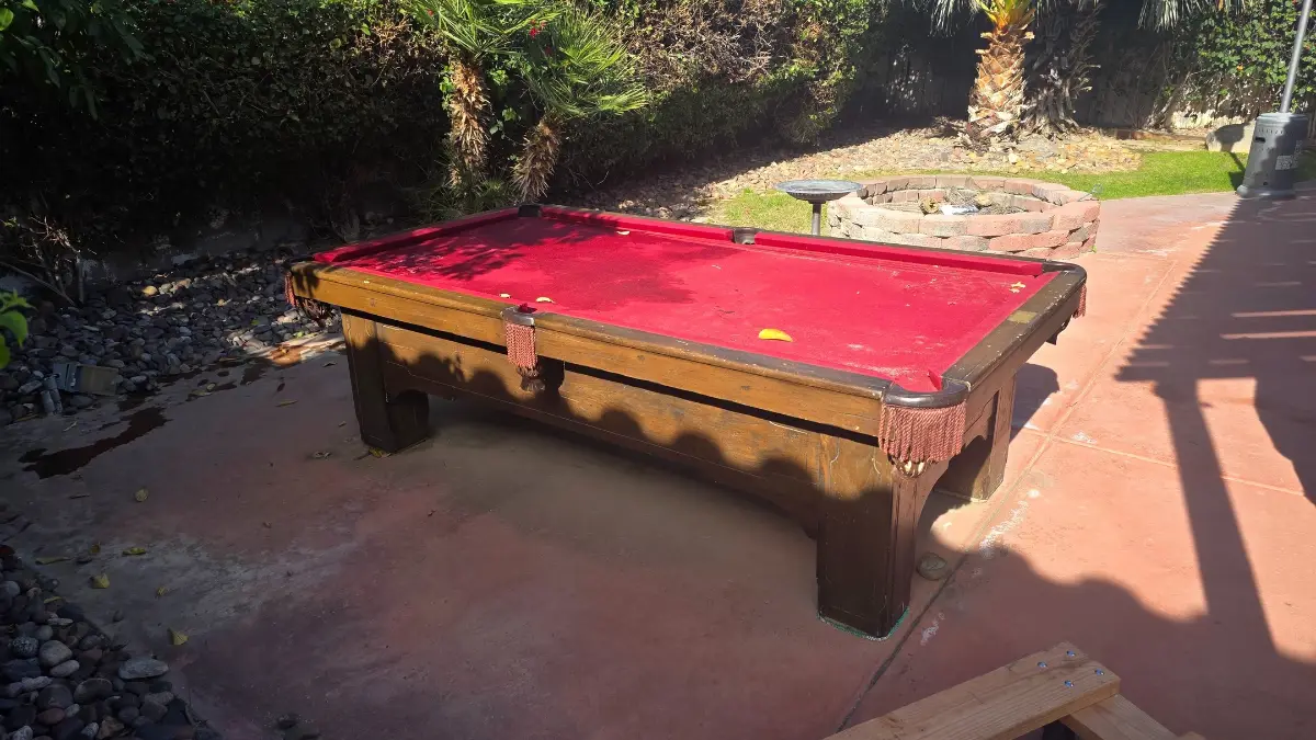 A red-felt pool table on a backyard patio in Queen Creek beside a fire pit