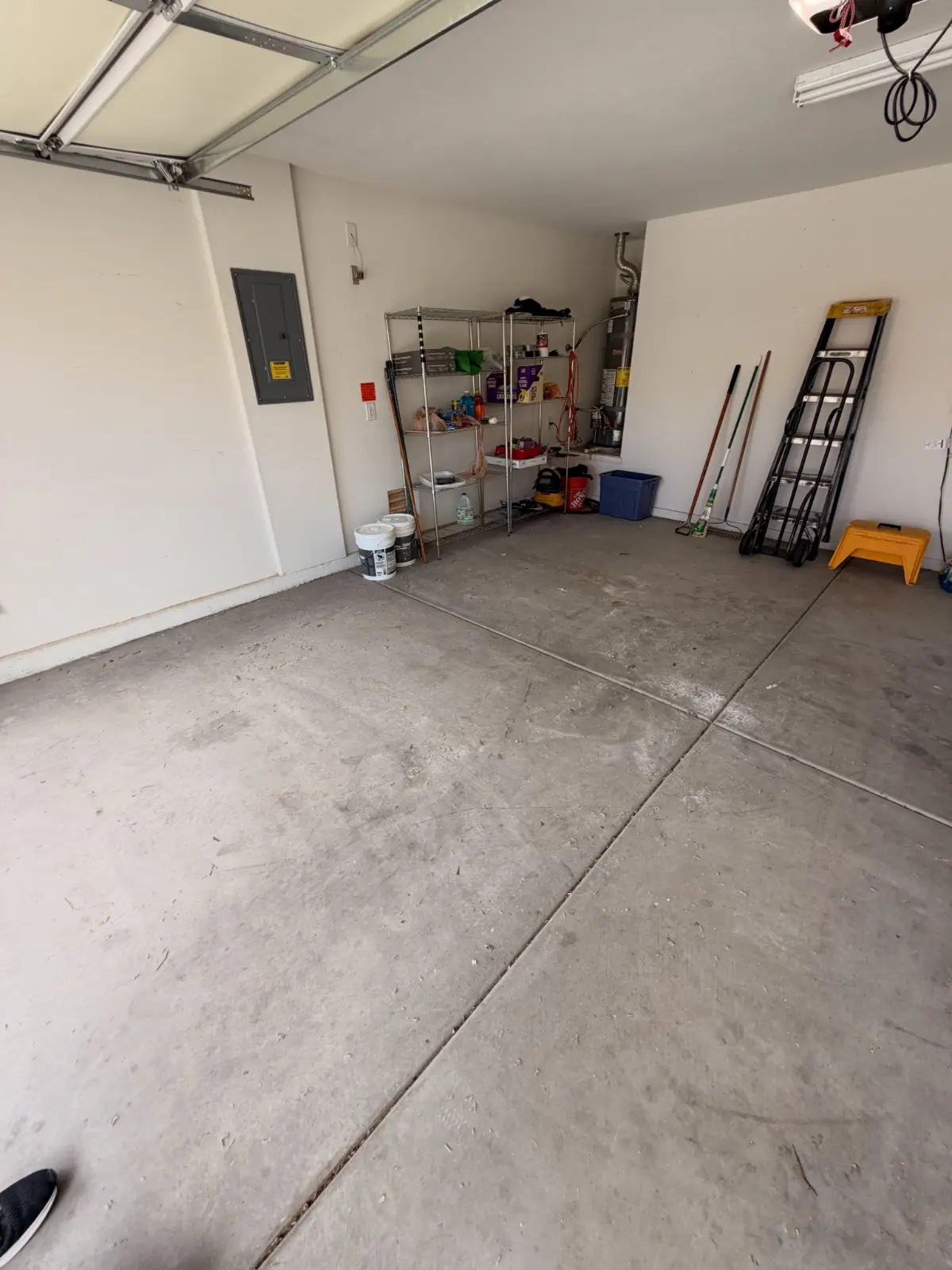 The same Scottsdale garage floor clear to the slab; shelving and the water heater remain