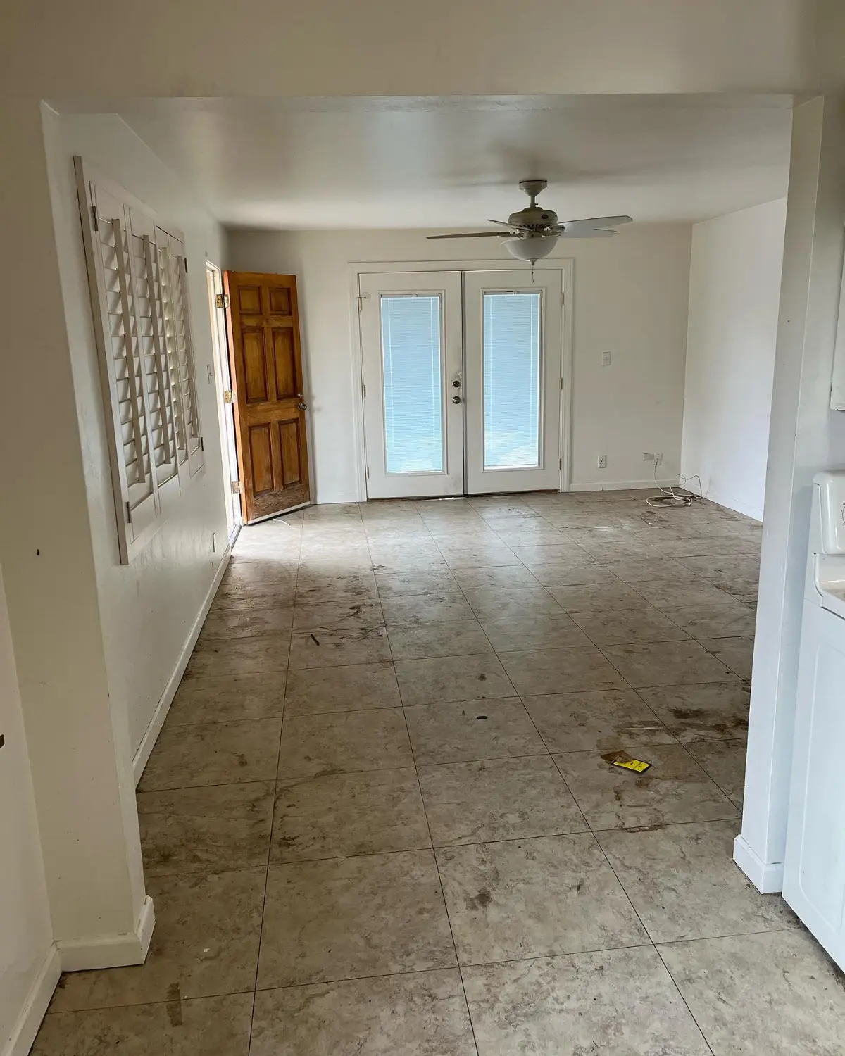 The same Scottsdale living room empty with the french doors and tile clear
