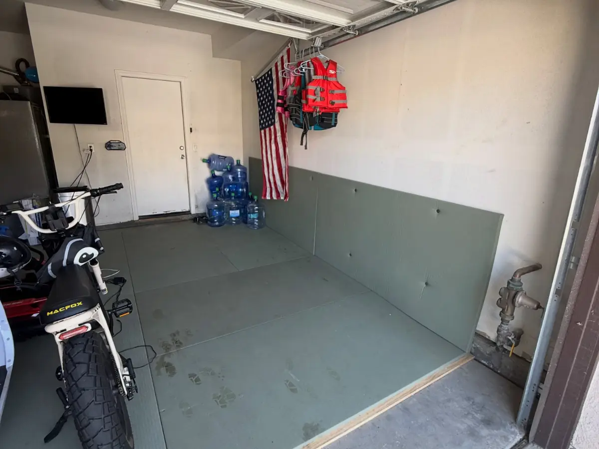 The same Scottsdale garage bay cleared to the mats; the flag, life jackets and water jugs remain