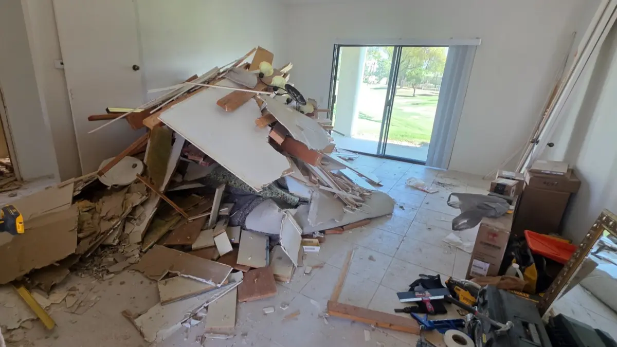 Drywall, framing lumber and pulled carpet piled in a Sun Lakes living room by the patio doors