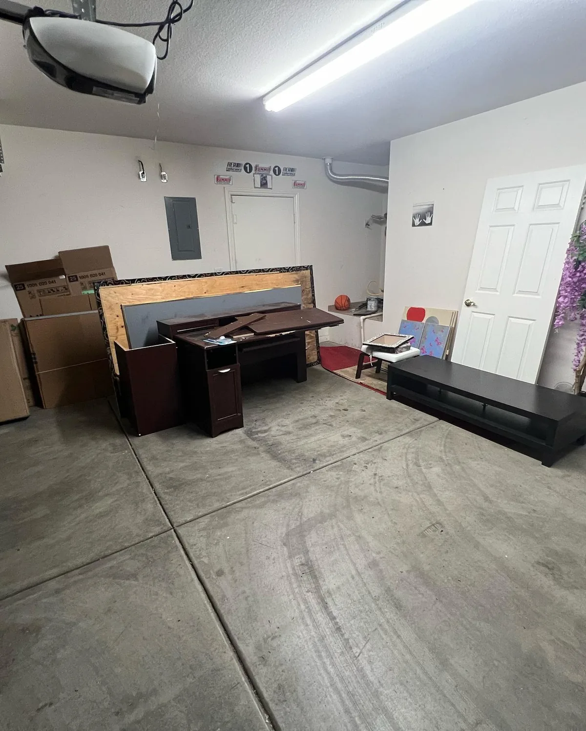 Furniture, boxes, shelving, and household items in a Tempe garage before junk removal