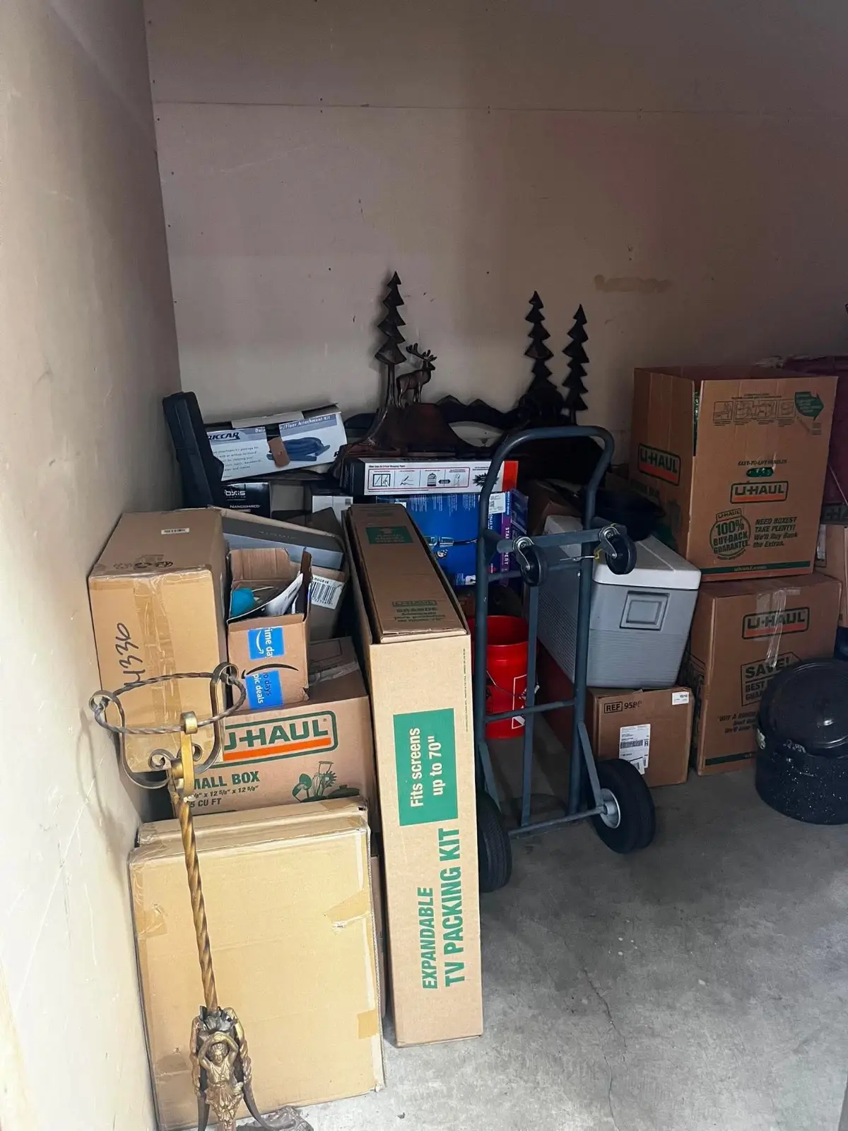 A Tempe storage unit packed to the walls with moving boxes, a hand truck, a cooler and household goods